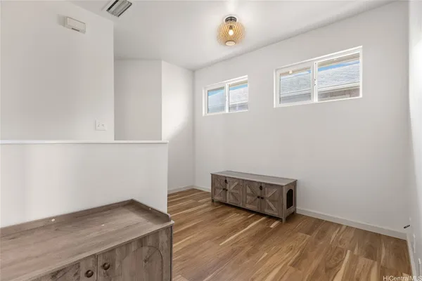 a view of empty room with wooden floor