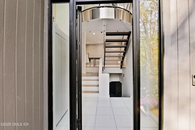 a view of a hallway with wooden floor and staircase