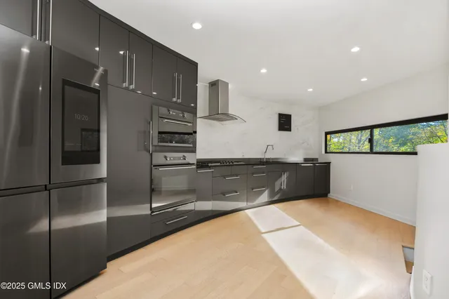 a view of kitchen with stainless steel appliances kitchen island granite countertop a refrigerator and a sink