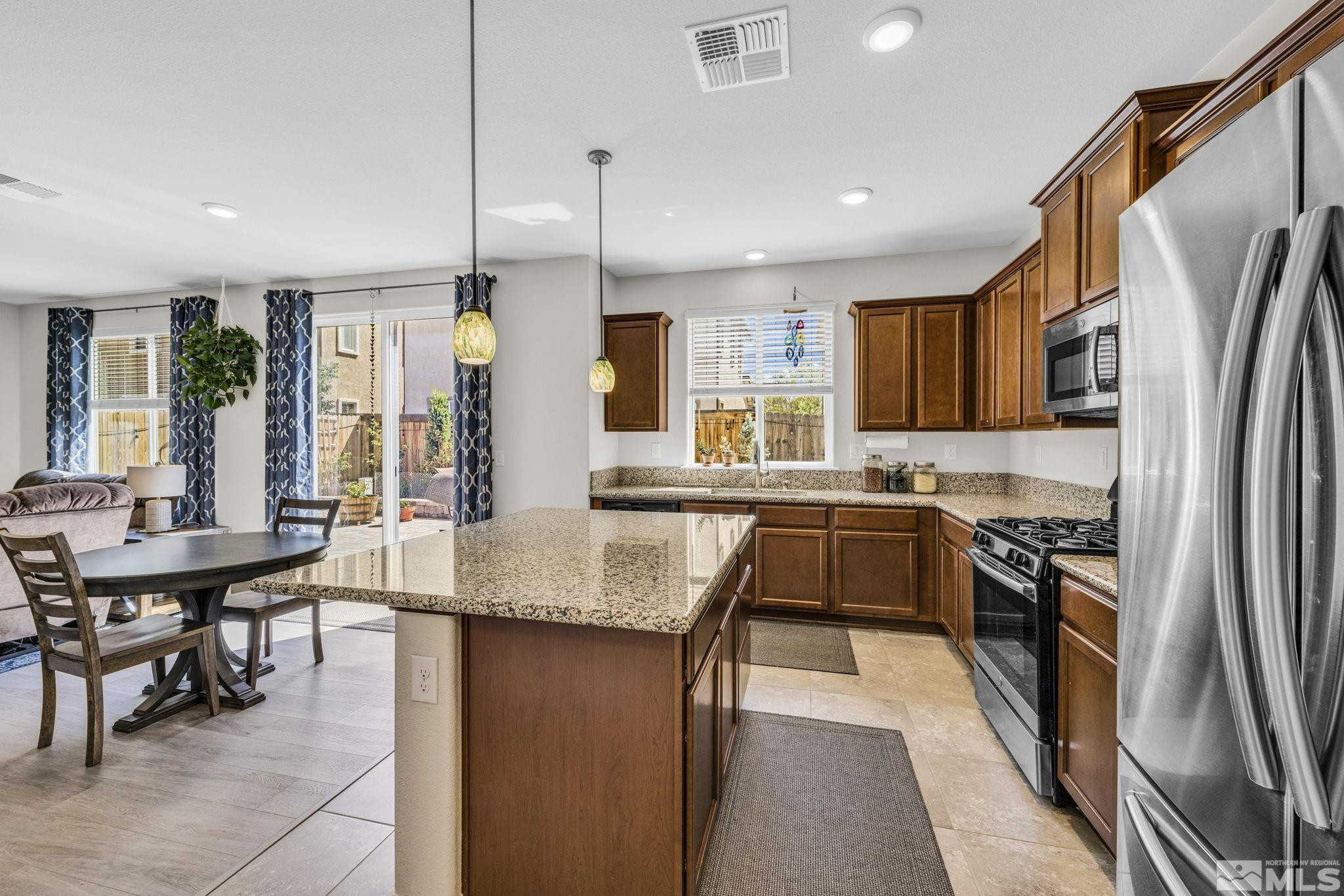 2215 Symphony Way Reno, NV 89521 - Photo 4 of 39 a kitchen with stainless steel appliances granite countertop sink refrigerator and cabinets