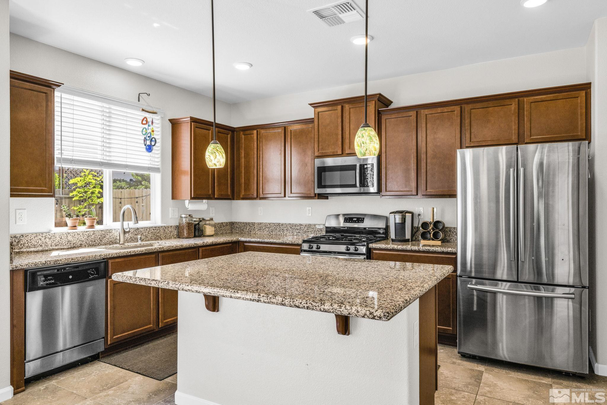 2215 Symphony Way Reno, NV 89521 - Photo 7 of 39 a kitchen with stainless steel appliances granite countertop a sink stove and refrigerator