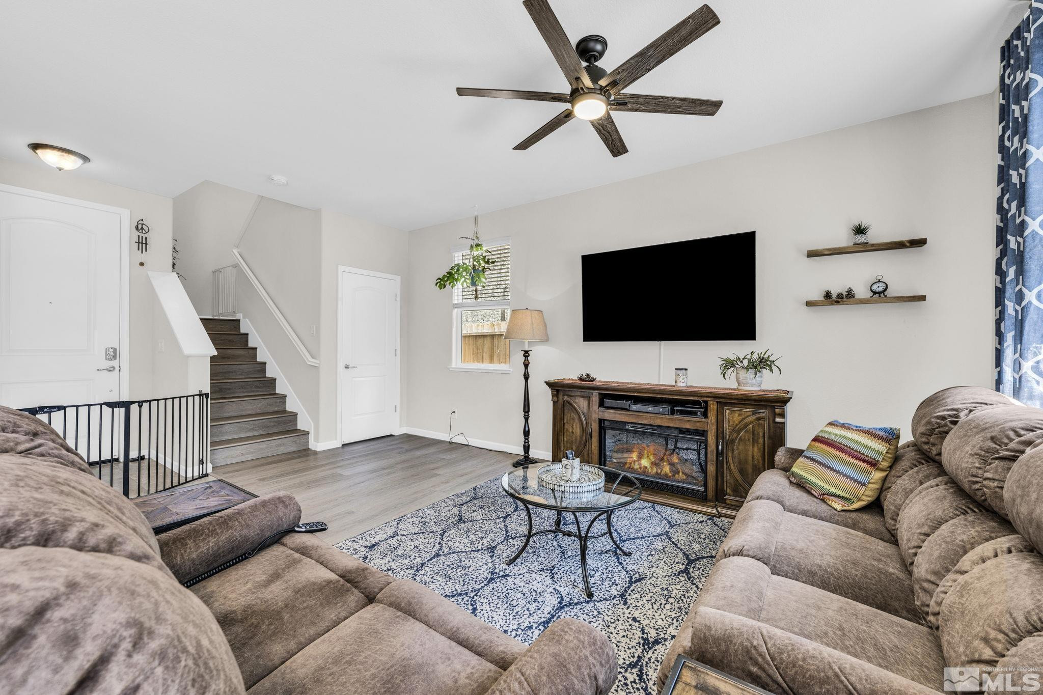 2215 Symphony Way Reno, NV 89521 - Photo 8 of 39 a living room with furniture a flat screen tv and a fireplace
