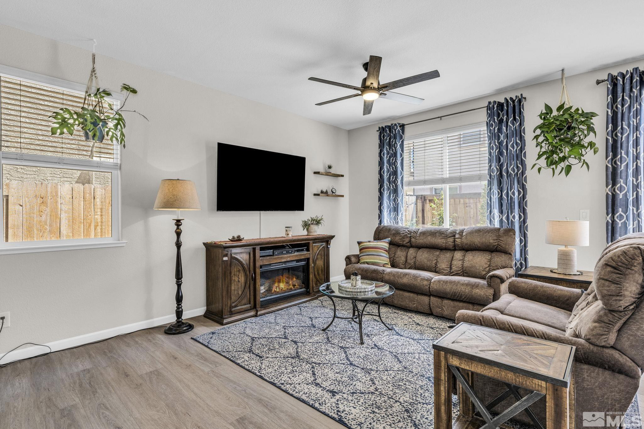 2215 Symphony Way Reno, NV 89521 - Photo 9 of 39 a living room with furniture a fireplace and a flat screen tv