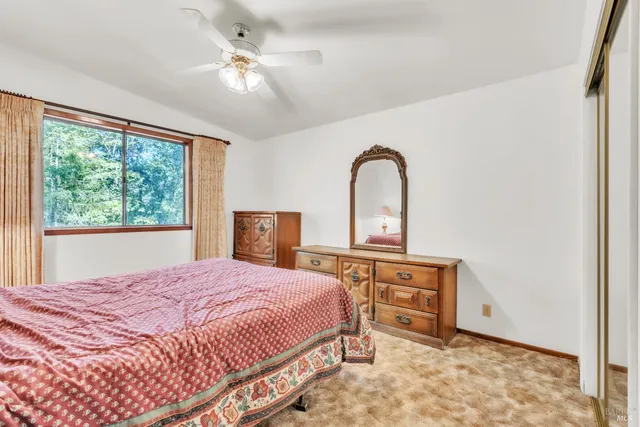 a bedroom with a bed and a dresser next to a window