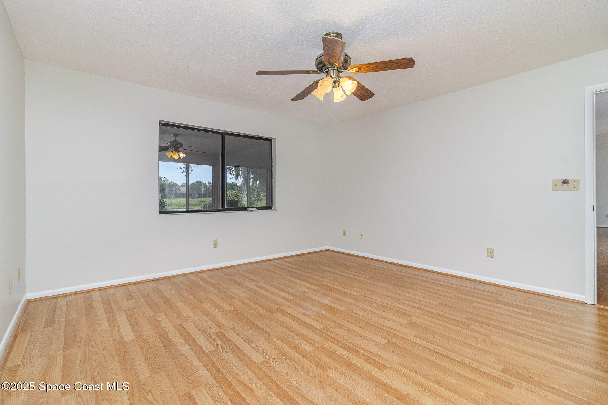1570 Frontier Drive Melbourne, FL 32940 - Photo 15 of 43 a view of empty room with wooden floor and fan