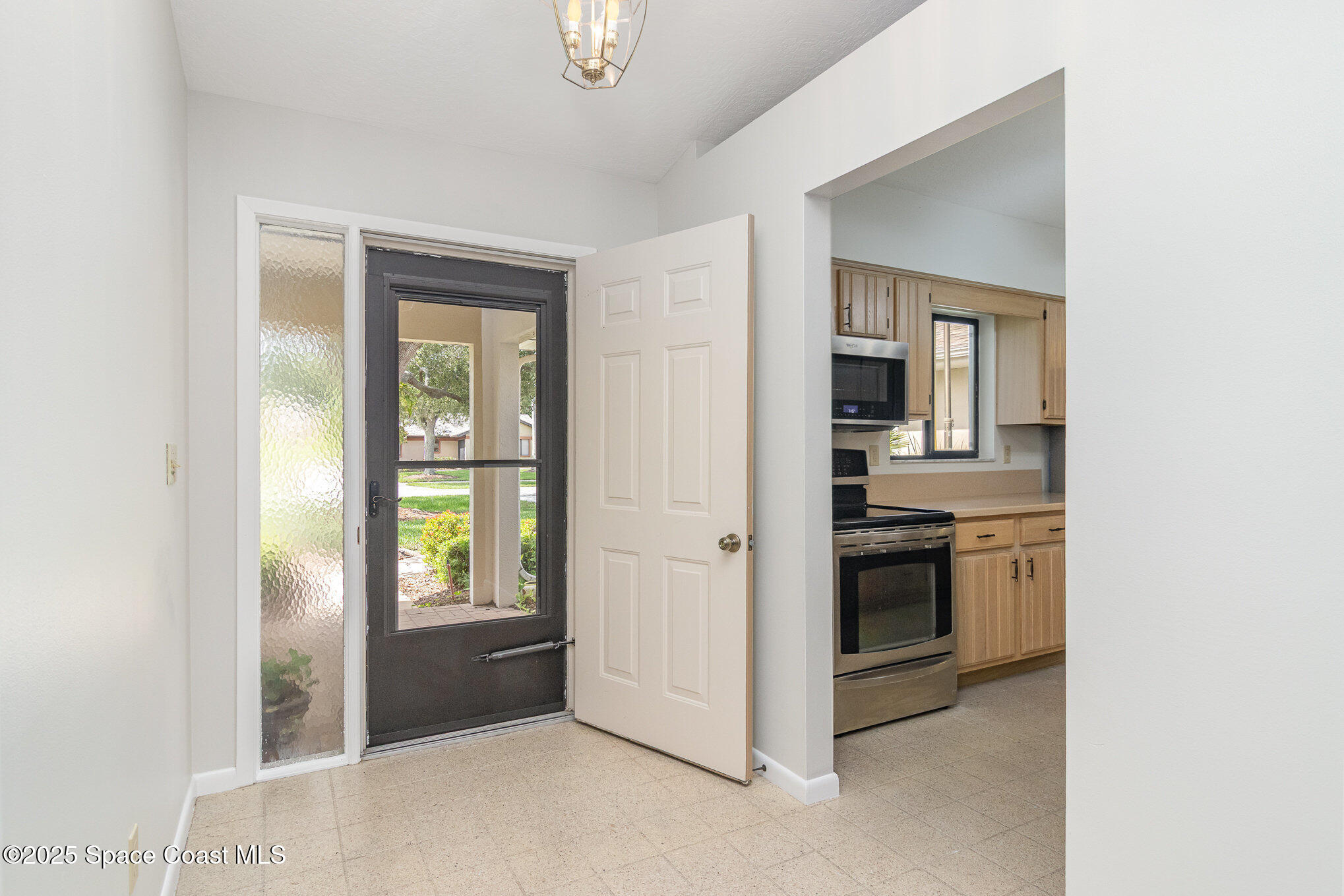 1570 Frontier Drive Melbourne, FL 32940 - Photo 3 of 43 an empty room with windows and kitchen view