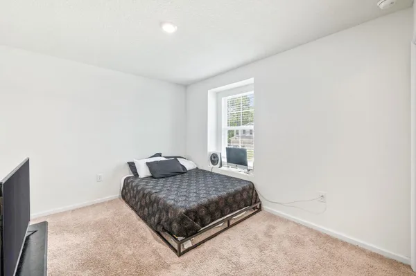a bedroom with a bed and a window
