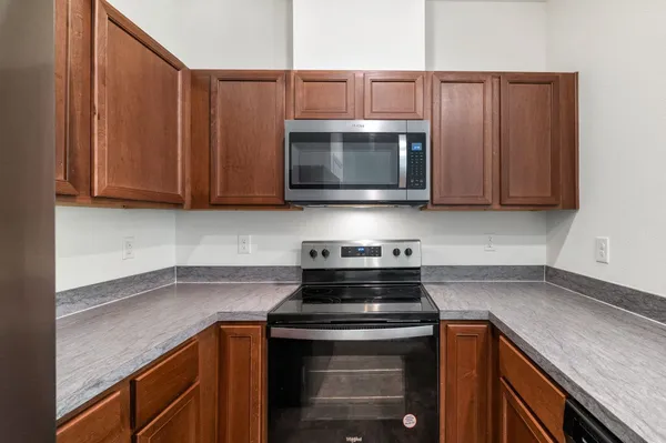a kitchen with stainless steel appliances granite countertop a stove a microwave and cabinets
