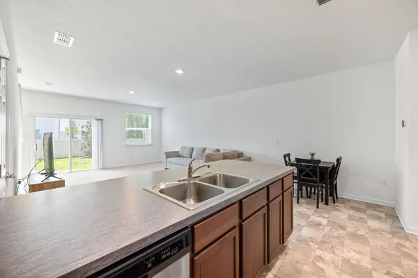 a kitchen with a sink and chairs