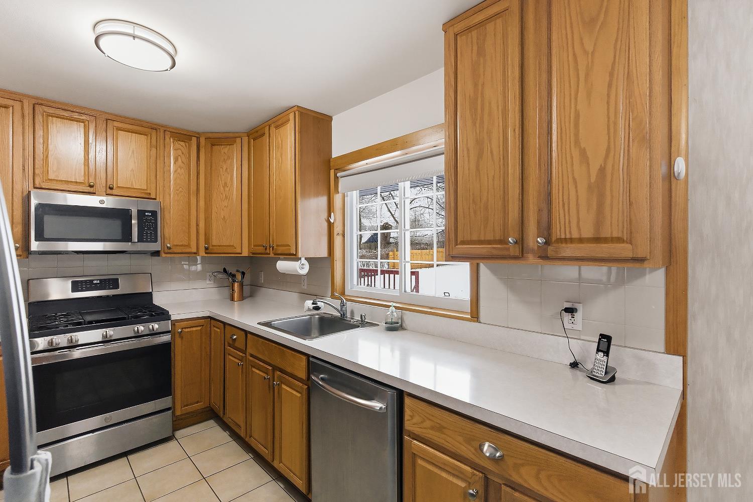 10 Cranston Road Kendall Park, NJ 08824 - Photo 11 of 27 a kitchen with a sink a counter top space cabinets and stainless steel appliances