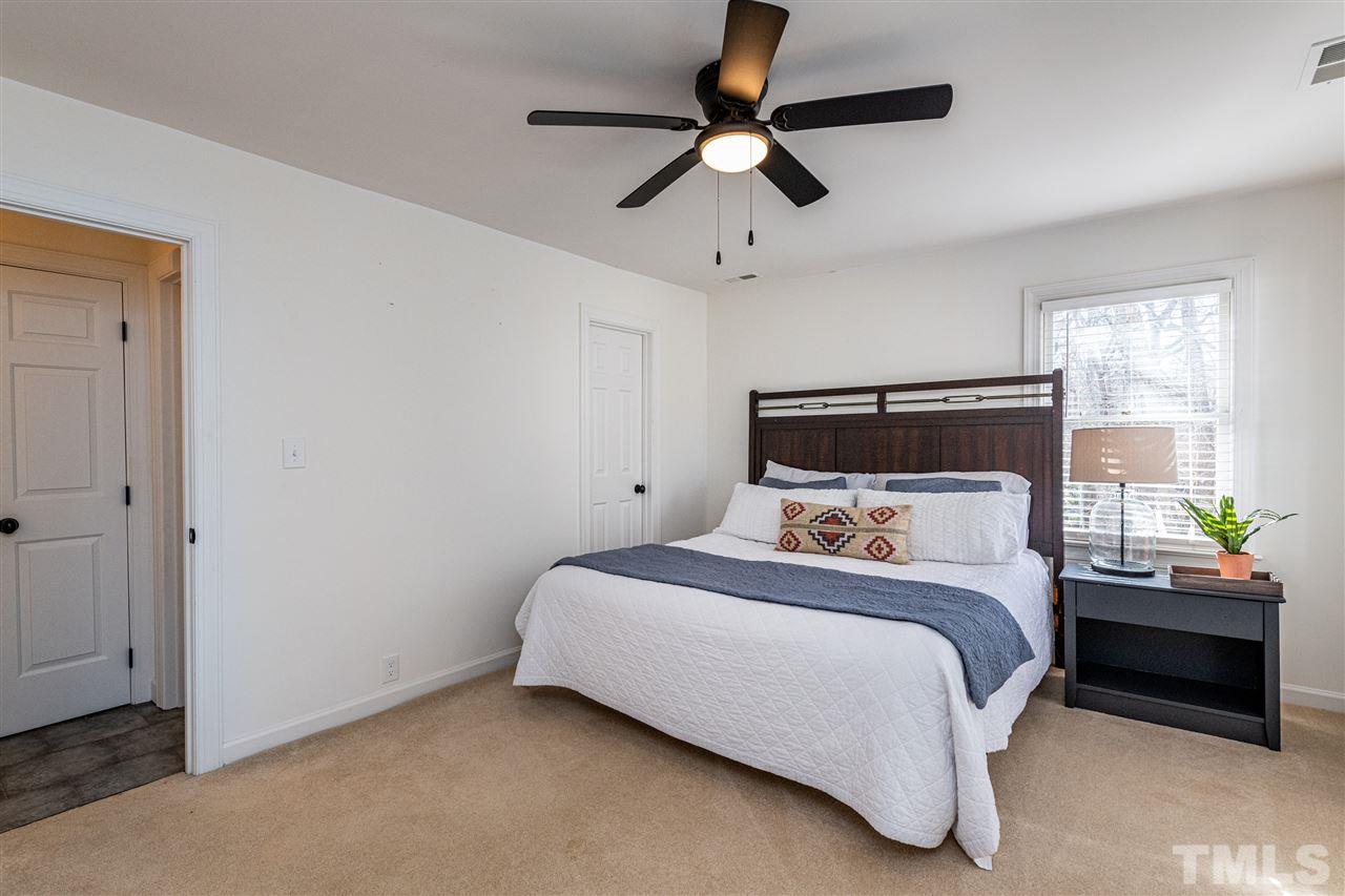 8105 Iron Bark Court Raleigh, NC 27606 - Photo 20 of 30 a bedroom with a bed and a ceiling fan