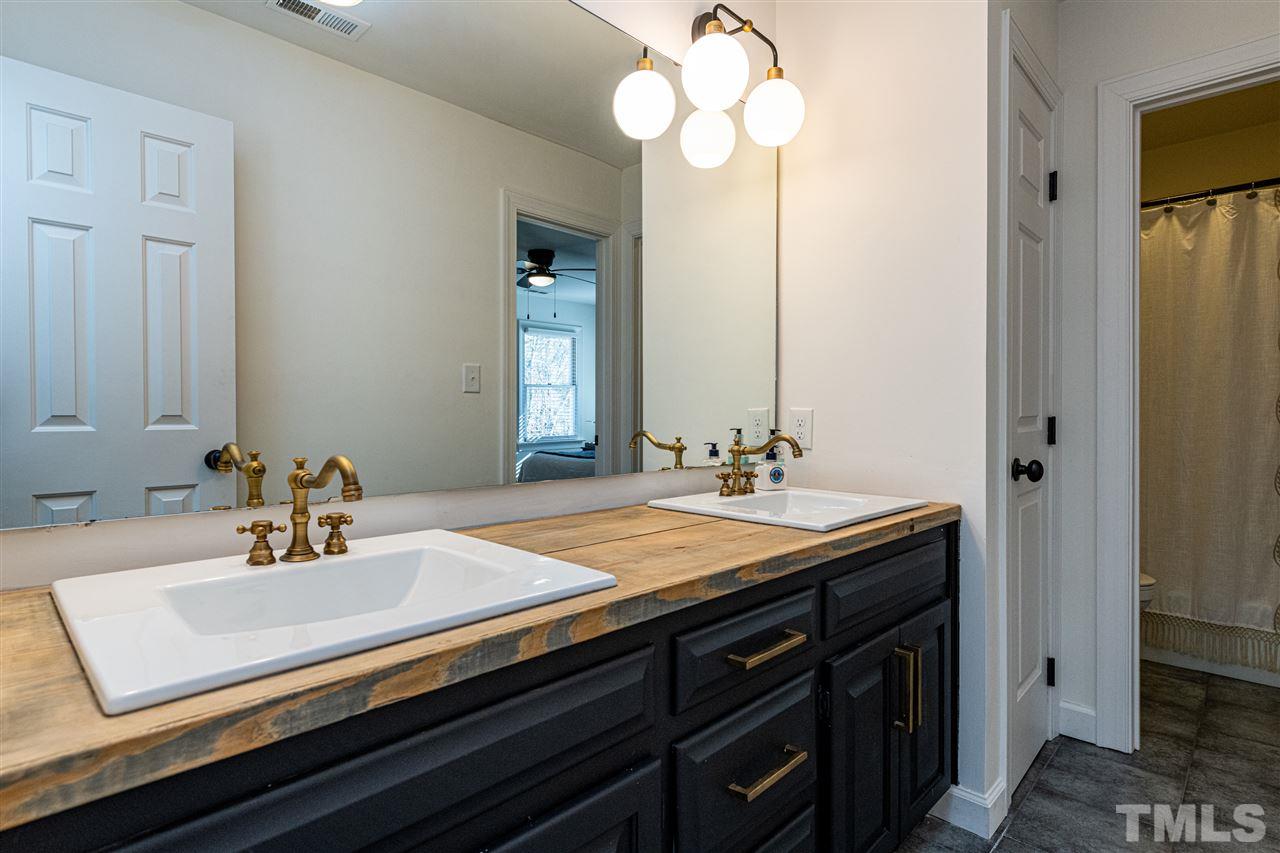 8105 Iron Bark Court Raleigh, NC 27606 - Photo 21 of 30 a bathroom with a sink double vanity and a mirror