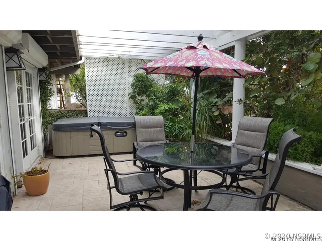 a backyard of a house with table and chairs