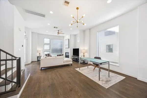 a living room with furniture and a wooden floor