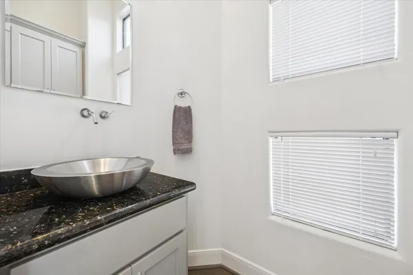 a bathroom with a granite countertop sink and a mirror