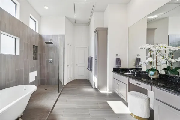 a spacious bathroom with a granite countertop sink a toilet a mirror and shower