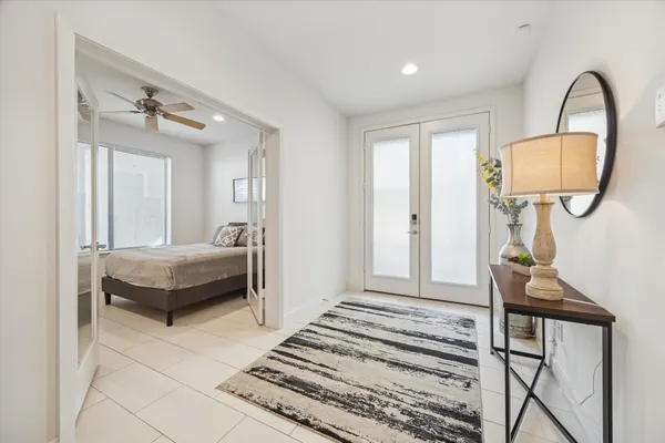 a bedroom with a bed a mirror and table