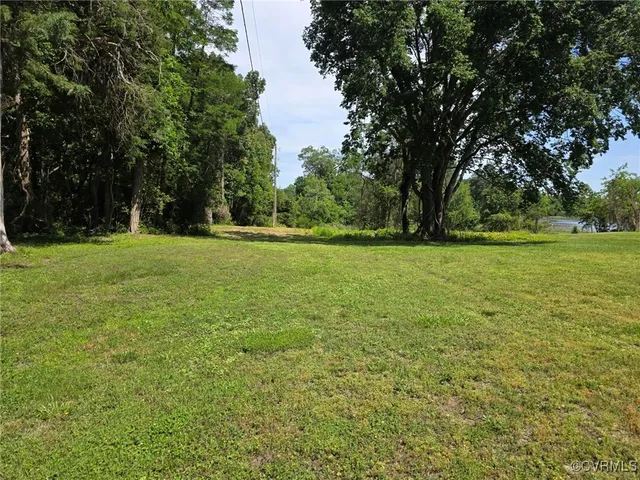 a view of a green field with trees in the background