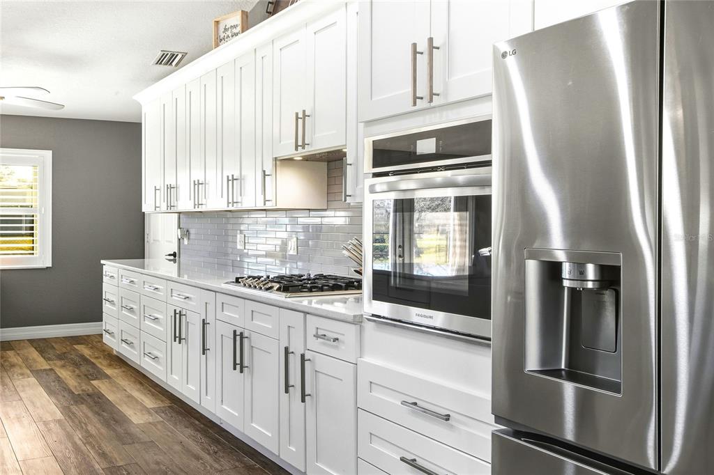 533 Seven Oaks Street Mulberry, FL 33860 - Photo 11 of 43 a kitchen with stainless steel appliances a refrigerator sink and cabinets