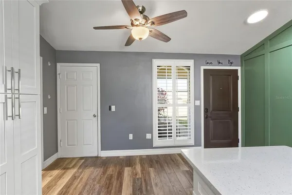 a view of an empty room with a window and a kitchen