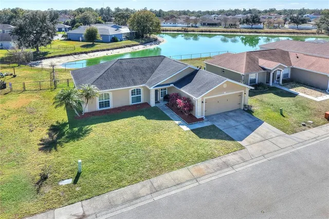 an aerial view of a house with outdoor space and lake view