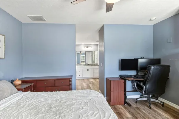 a bedroom with a bed and a computer on the desk