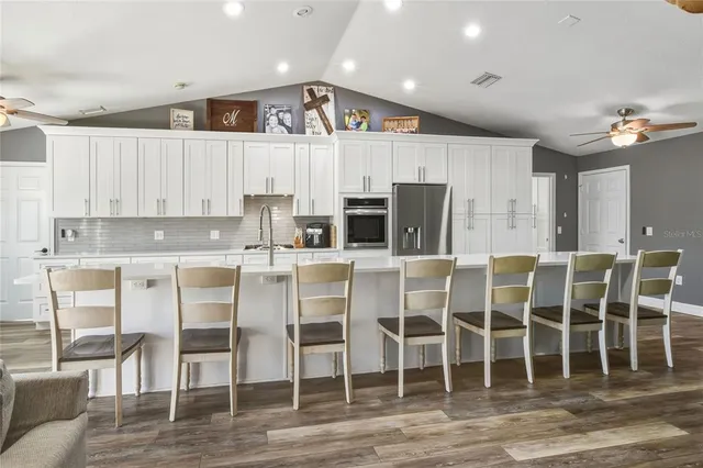 a kitchen with cabinets and chairs