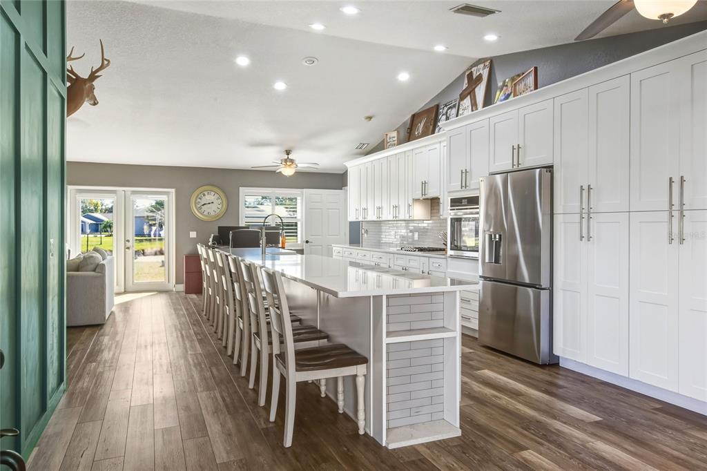 533 Seven Oaks Street Mulberry, FL 33860 - Photo 8 of 43 a kitchen with stainless steel appliances granite countertop a refrigerator oven a sink a dining table and chairs with wooden floor