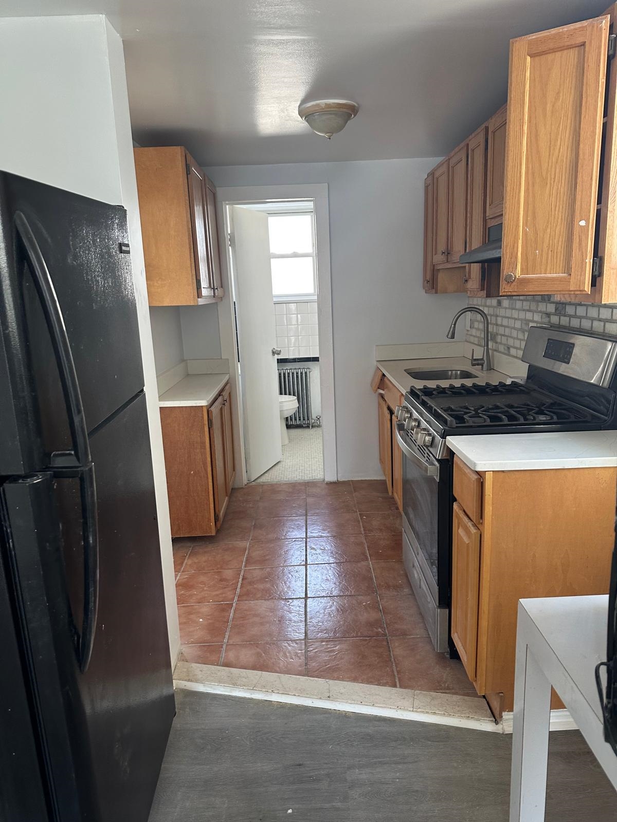 31 East 32nd Street, Unit 2 Bayonne, NJ 07002 - Photo 15 of 19 a kitchen with stainless steel appliances granite countertop a refrigerator stove and sink