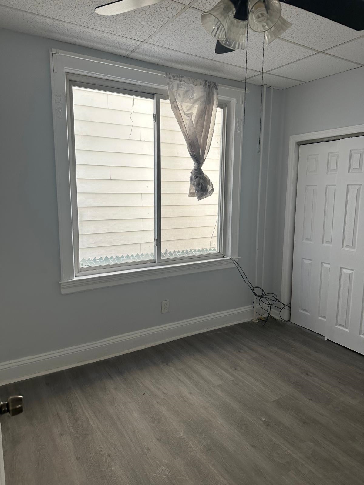 31 East 32nd Street, Unit 2 Bayonne, NJ 07002 - Photo 4 of 19 an empty room with wooden floor and windows
