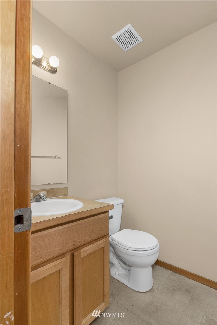 6912 Radius Loop Southeast Lacey, WA 98513 - Photo 11 of 30 a bathroom with a toilet a sink and mirror