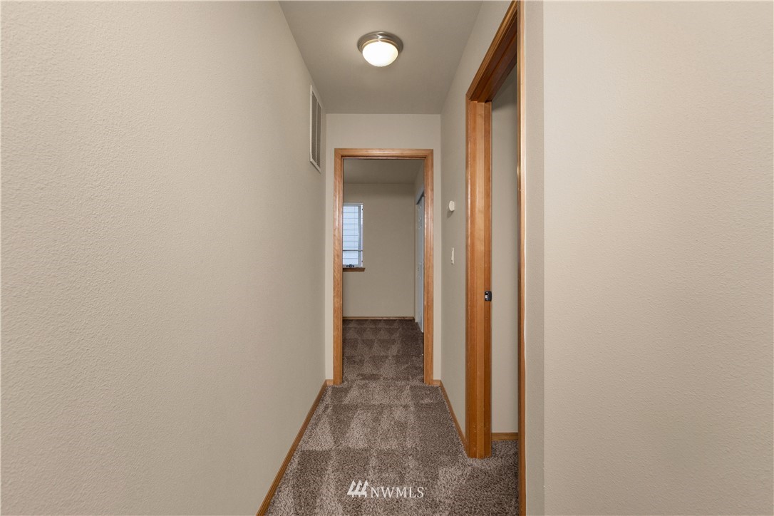6912 Radius Loop Southeast Lacey, WA 98513 - Photo 16 of 30 a view of a hallway with wooden floor and a bathroom