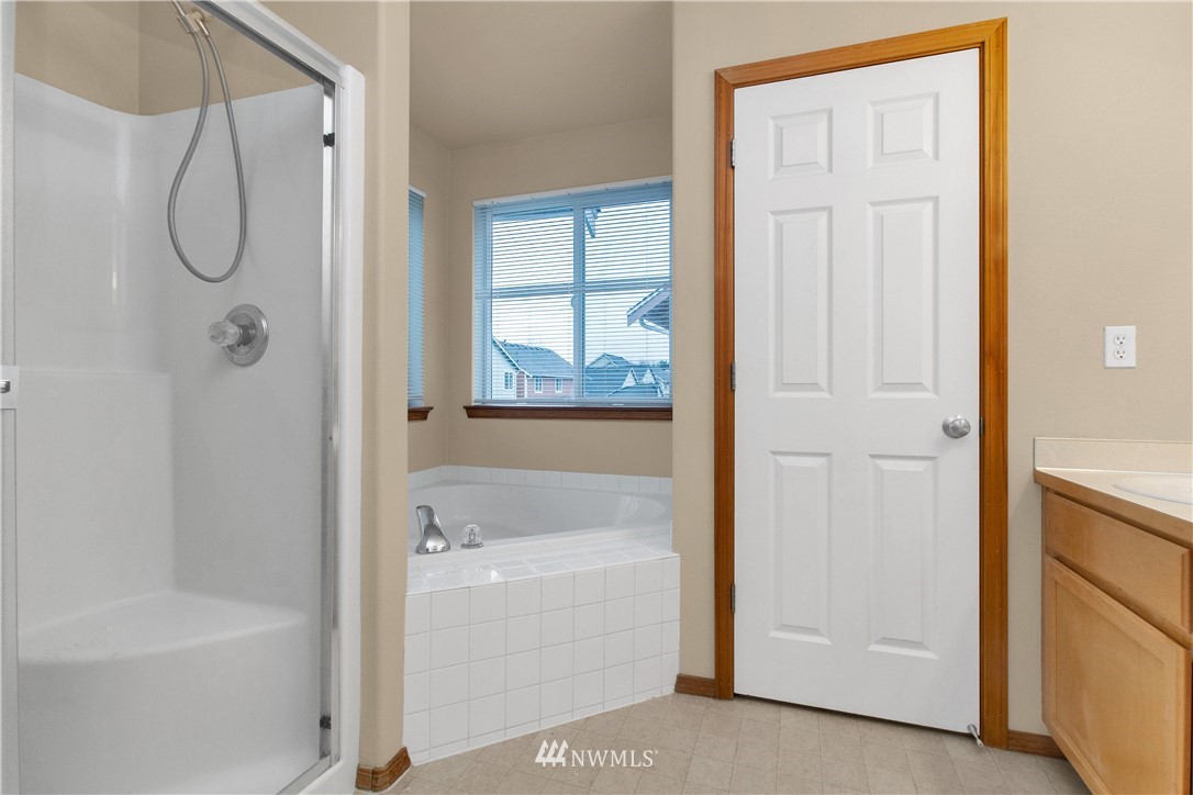 6912 Radius Loop Southeast Lacey, WA 98513 - Photo 20 of 30 a bathroom with a bathtub a shower and a window