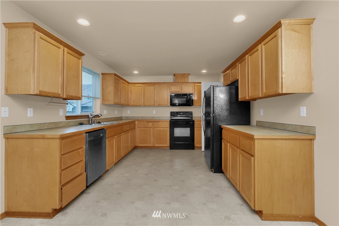 6912 Radius Loop Southeast Lacey, WA 98513 - Photo 6 of 30 a kitchen with stainless steel appliances granite countertop a stove refrigerator sink and cabinets