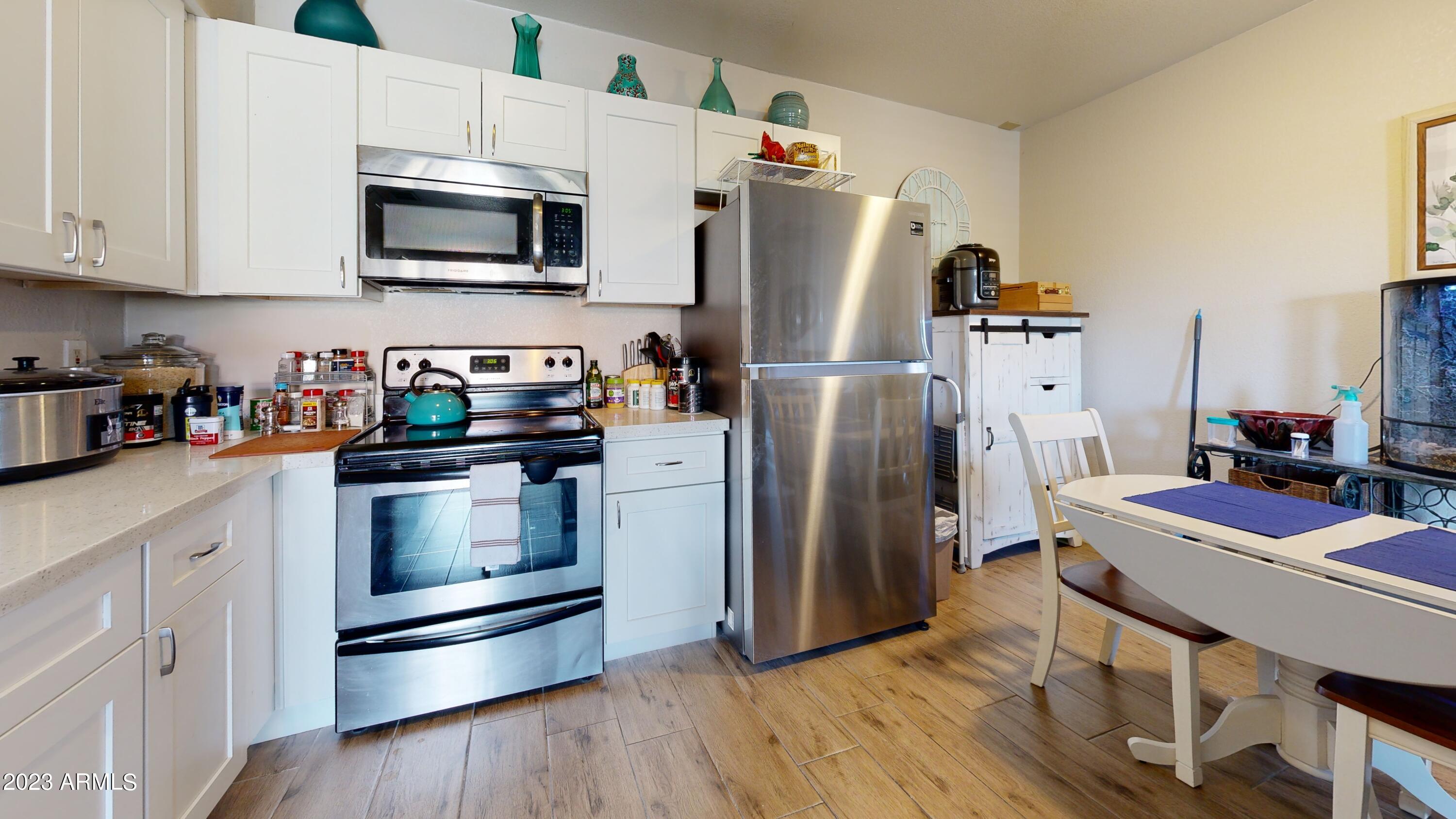 1440 North Idaho Road, Unit 1098 Apache Junction, AZ 85119 - Photo 2 of 10 a kitchen with stainless steel appliances a refrigerator stove and microwave