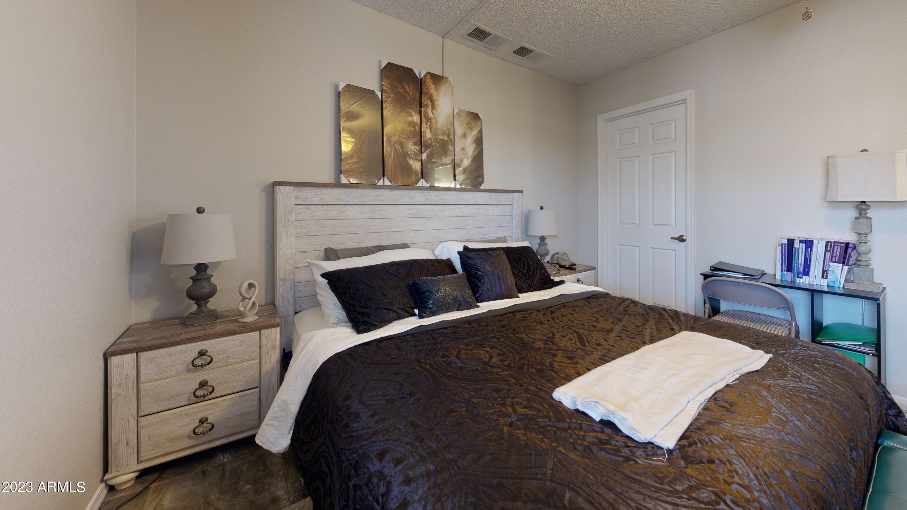 1440 North Idaho Road, Unit 1098 Apache Junction, AZ 85119 - Photo 8 of 10 a bedroom with a bed and a table in it