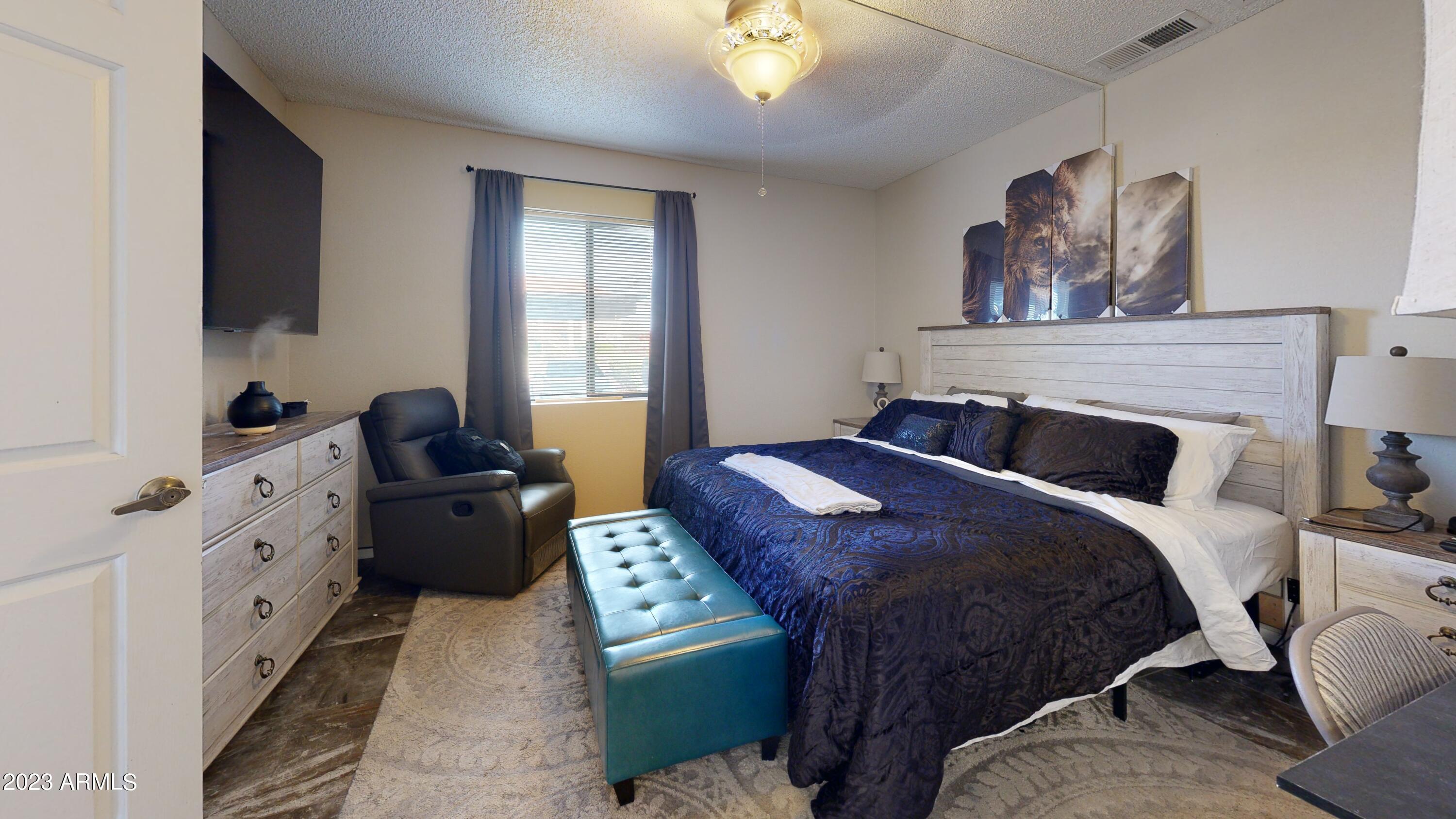 1440 North Idaho Road, Unit 1098 Apache Junction, AZ 85119 - Photo 9 of 10 a bedroom with a bed and a flat screen tv