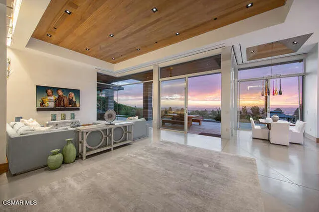 a kitchen with stainless steel appliances granite countertop a stove top oven a sink dishwasher a dining table and chairs with wooden floor