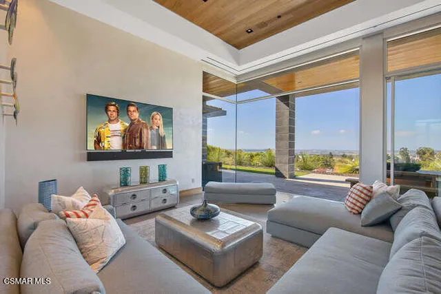 a view of a living room with a floor to ceiling window and wooden floor