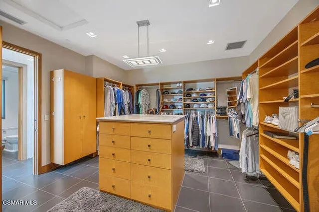 a large kitchen with kitchen island granite countertop a stove a sink dishwasher a dining table and chair with wooden floor