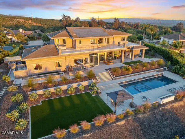 a view of pool with brick walls plants and large tree