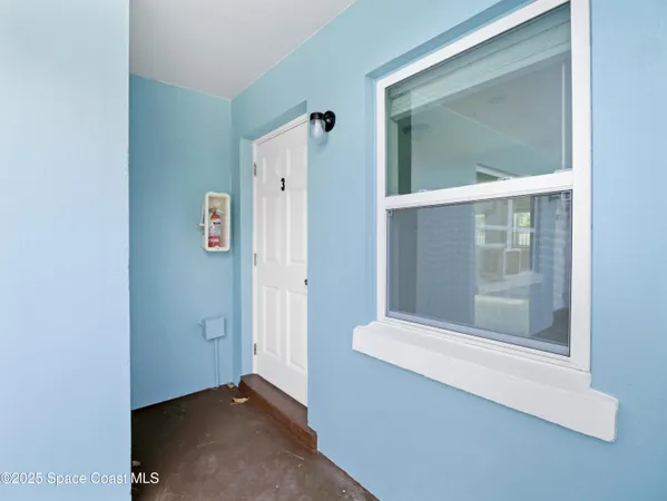 an empty room with a kitchen and a ceiling fan