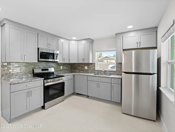 a kitchen with white cabinets appliances and a sink