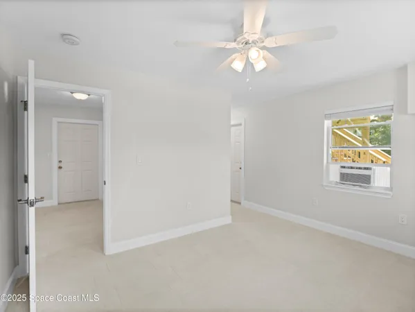 a view of a room with a ceiling fan and bathroom