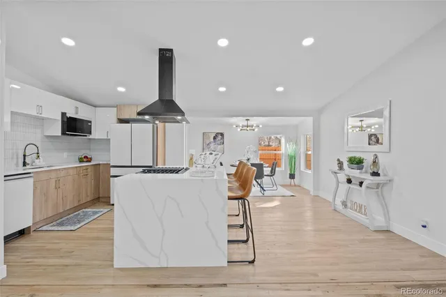 a large kitchen with white cabinets table and chairs