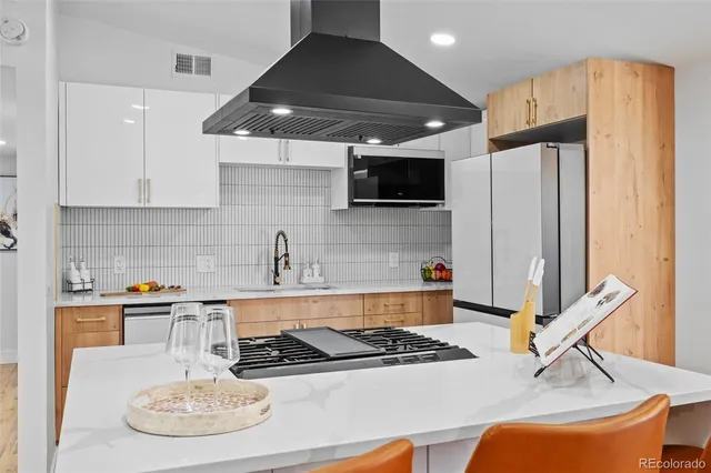 a kitchen with stainless steel appliances granite countertop a sink a stove and a refrigerator