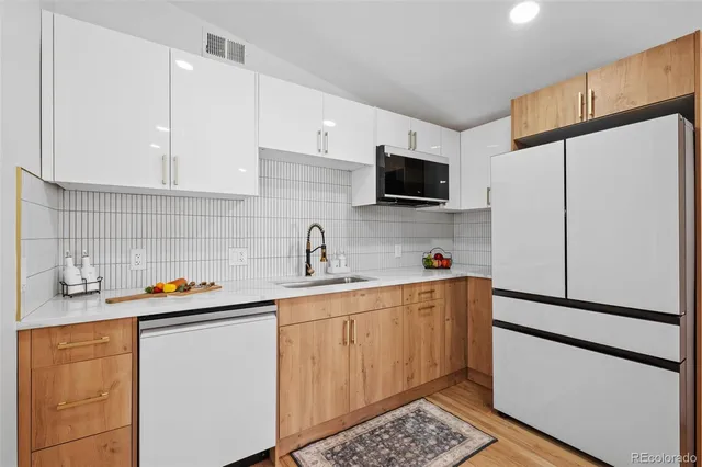 a kitchen with stainless steel appliances a refrigerator sink and microwave