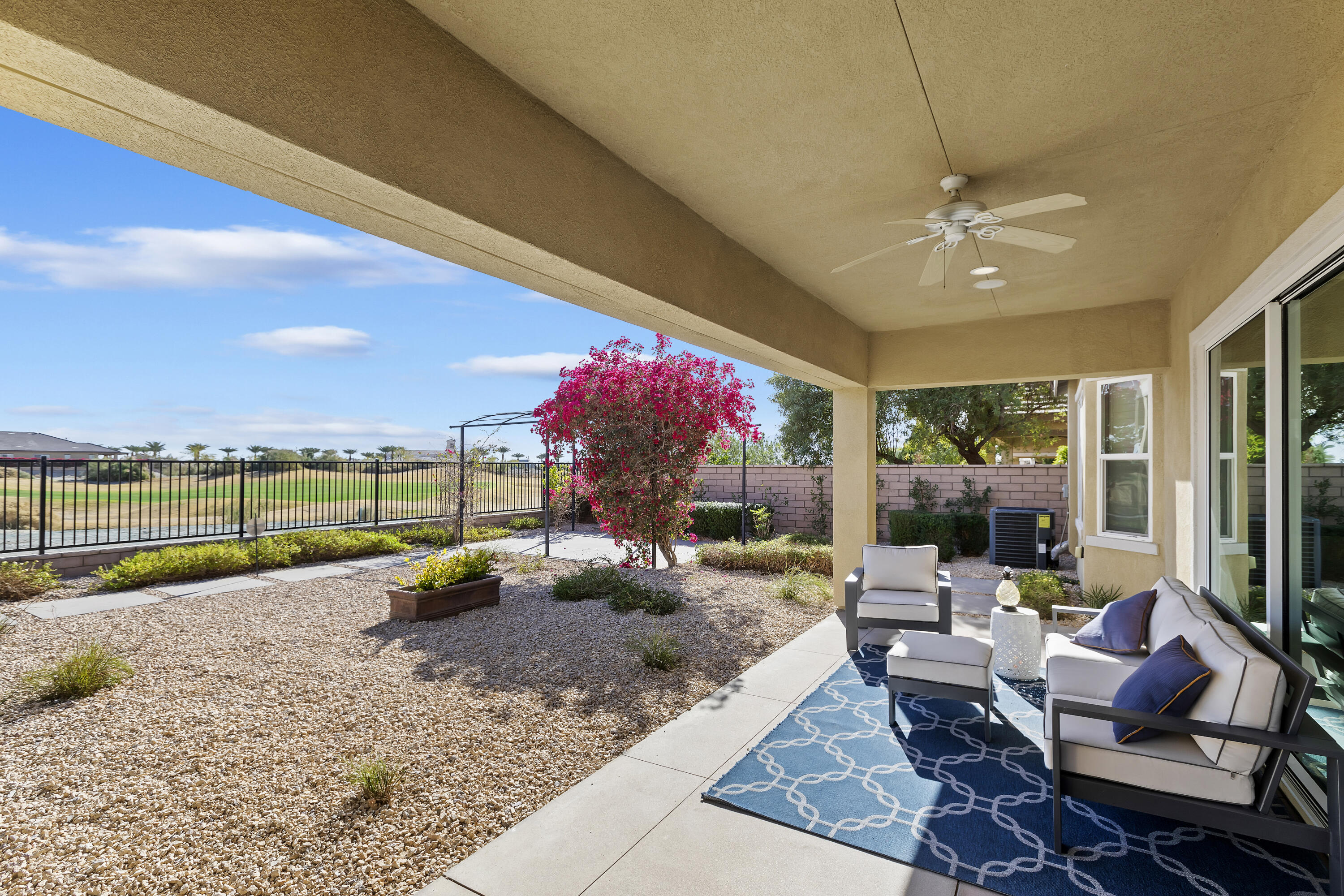 a living room with patio furniture and a floor to ceiling window