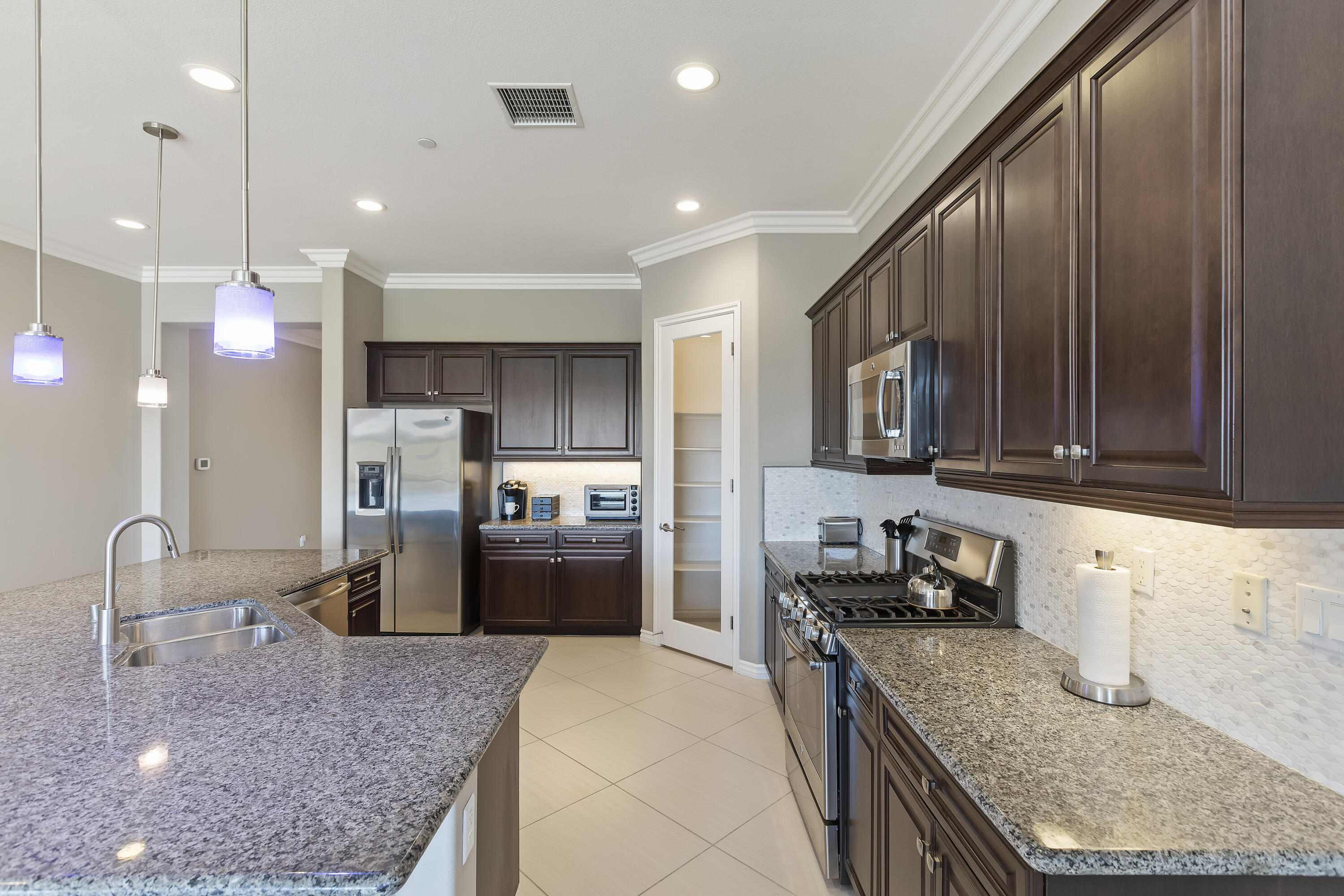 43020 Ascona Lane Indio, CA 92203 - Photo 12 of 33 a kitchen with stainless steel appliances granite countertop a sink refrigerator and cabinets