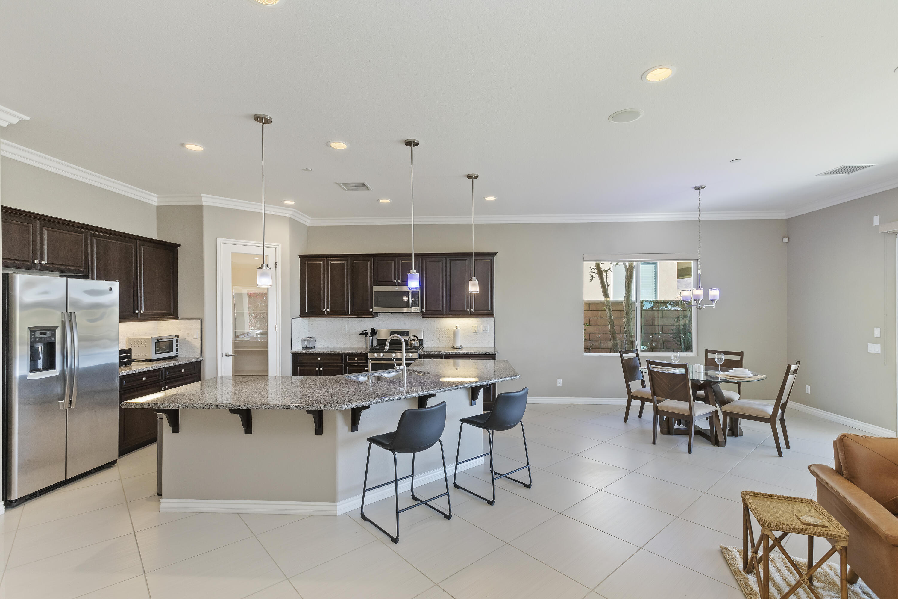 43020 Ascona Lane Indio, CA 92203 - Photo 13 of 33 a kitchen with stainless steel appliances kitchen island granite countertop a sink and cabinets
